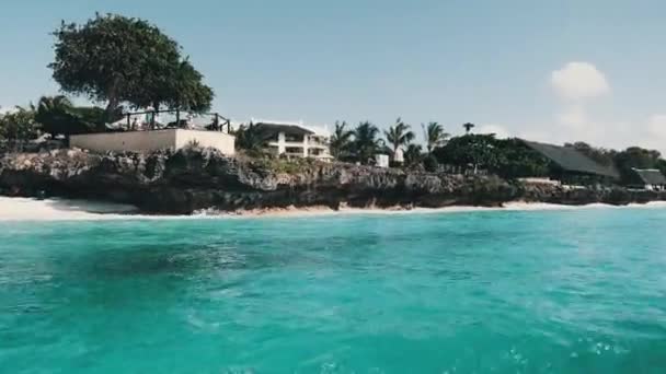 サンディビーチ、パーム、ホテルとZanzibar海岸線。フローティングボートからの眺め — ストック動画