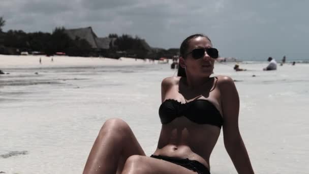 Młoda kobieta w czarnym bikini opalenizna na raju Biała piaszczysta plaża leży nad oceanem — Wideo stockowe