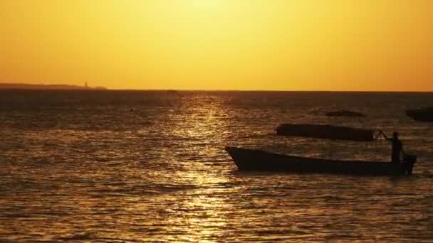 Silhueta de barcos de pesca ancorada ao pôr do sol no Oceano Índico, Zanzibar — Vídeo de Stock