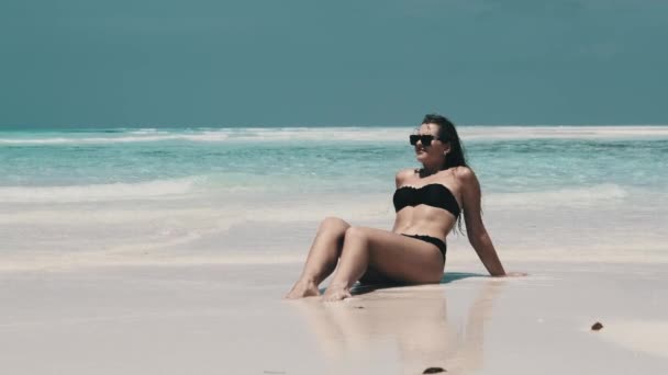 Jovem mulher de biquíni bronzeada em uma praia vazia do paraíso na ilha no oceano, Mnemba — Vídeo de Stock