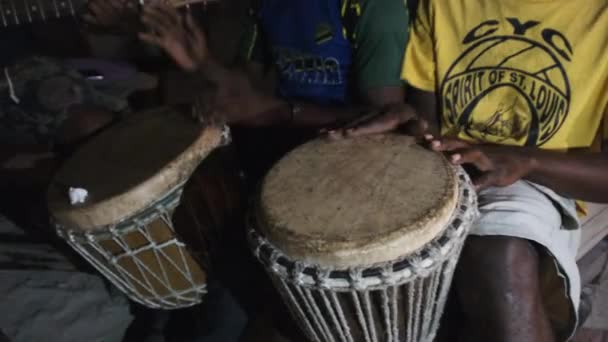 Giovani africani locali suonano la chitarra con il djembe, cantano canzoni intorno al falò, di notte — Video Stock