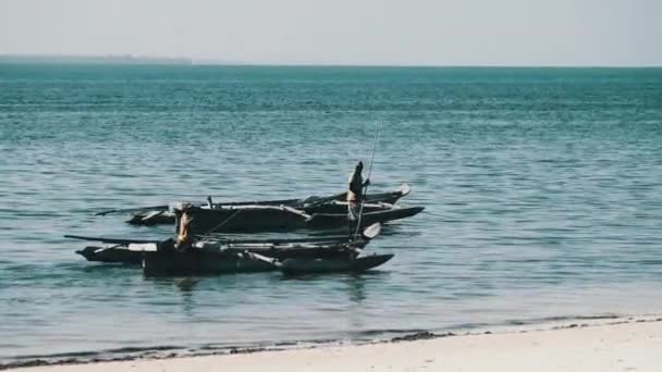 Pescatori africani sulla vecchia barca di legno Dhow galleggiante spingendo via con bastoni lunghi — Video Stock