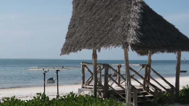 Reetgedeckter Sonnenschirm am Sandstrand am Meer, Strohschirm Sansibar, Afrika — Stockvideo