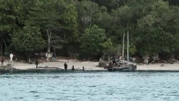 Village de pêcheurs africains locaux, les habitants déchargent le bateau de pêche Dhow au large de la côte — Video