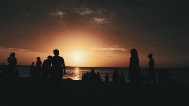Siluety lidí hrajících plážový volejbal při západu slunce, pomalý pohyb, Zanzibar — Stock video