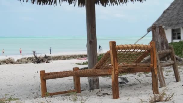 Trópusi fedélzet székek alatt Thatched esernyők Sandy Beach by Ocean, Zanzibar — Stock videók