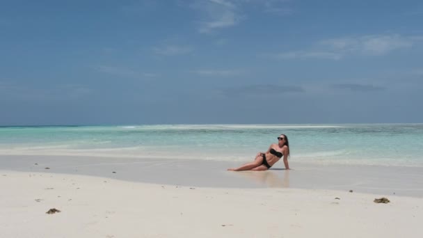 Jovem mulher de biquíni bronzeada em uma praia vazia do paraíso na ilha no oceano, Mnemba — Vídeo de Stock