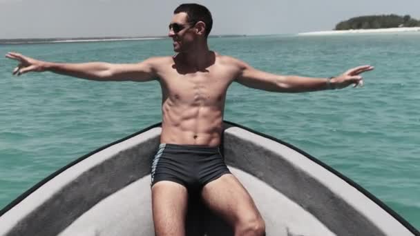 Jovem homem de sucesso com braços estendidos desfrutando no convés do barco no oceano — Vídeo de Stock