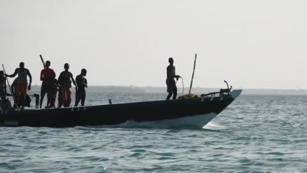 Pescadores africanos bailando divertidos en barco a motor de madera flotando por el océano, África — Vídeos de Stock