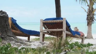 Ocean, Zanzibar 'ın Sandy Tropical Plajında Thatched Şemsiyeleri ve Güneş Salonları