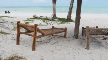 Ocean, Zanzibar 'daki Sandy Sahili' nde Thatched Şemsiyeleri Altında Tropikal Güverte Sandalyeleri