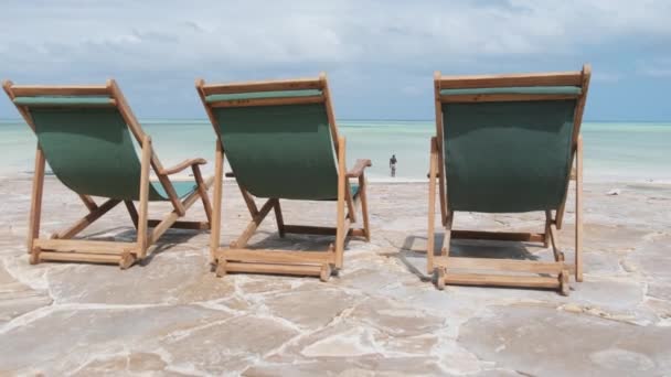 Three Empty Sun Loungers Stojí v řadě u oceánu na tropické pláži, Zadní pohled — Stock video