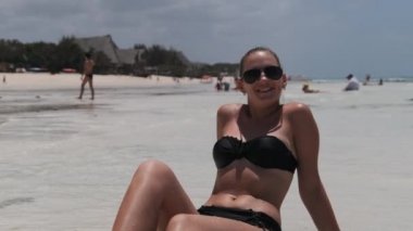 Siyah Bikinili Genç Kadın Cennetteki Beyaz Kumlu Kumsalda Ocean 'da yatıyor