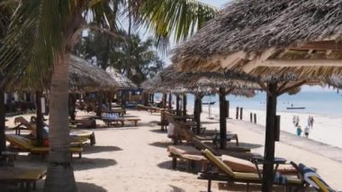 Ocean, Zanzibar yakınlarındaki Sandy Plajı 'nda Thatched Şemsiyeleri ve Güneş Salonları.