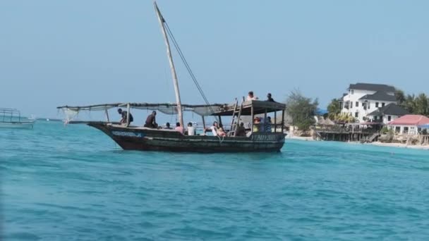 Barco Dhow tradicional con turistas flota en el océano frente a la costa, Zanzíbar — Vídeo de stock