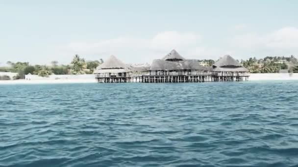 Ristorante africano con tetto spinato su pali di legno sopra l'oceano. Zanzibar — Video Stock