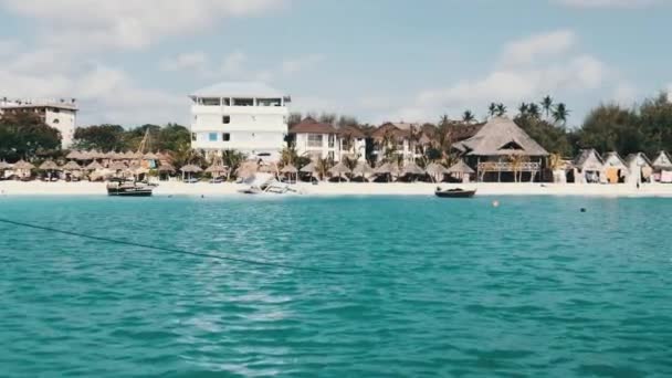 Costa de Zanzíbar con playa de arena, palmeras y hoteles. Vista desde barco flotante — Vídeos de Stock