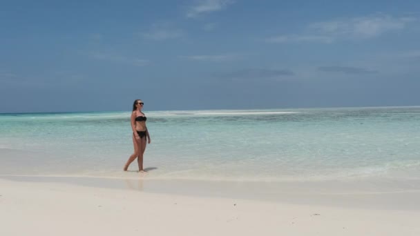 Mujer joven en bikini Camina en una playa vacía del paraíso en la isla en el océano, Mnemba — Vídeos de Stock