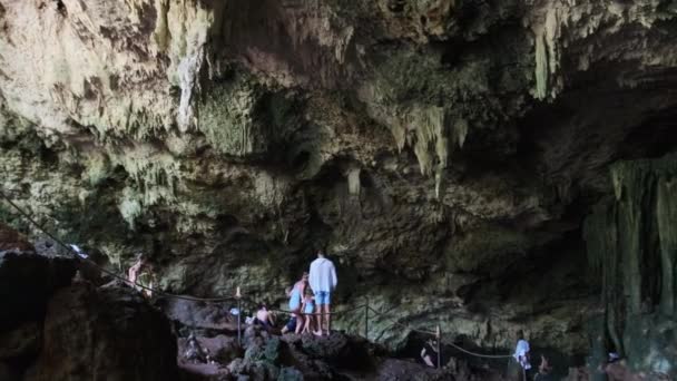 Personas en cuevas profundas nadan en el río subterráneo entre rocas y acantilados, Zanzíbar — Vídeo de stock