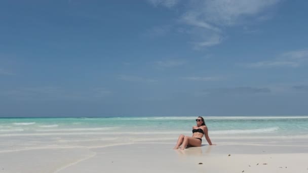 Jonge vrouw in Bikini Tans op een leeg paradijs strand op het eiland in Ocean, Mnemba — Stockvideo