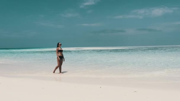 Jonge vrouw in Bikini Wandeling op een leeg paradijs strand op het eiland in Ocean, Mnemba — Stockvideo