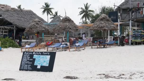 Trópusi strand szállodák és éttermek nádtetővel a parton óceán mellett — Stock videók