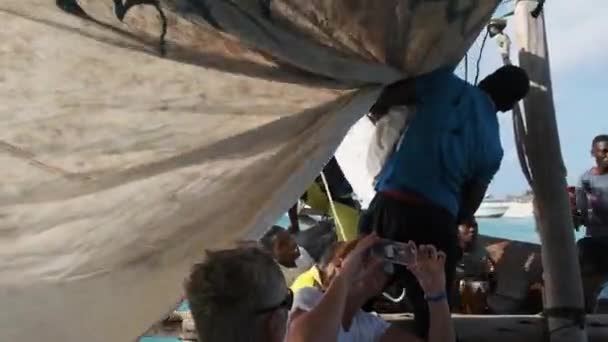 Einheimische Afrikaner stechen mit Touristen auf dem Dhow-Ausflugsschiff Sansibar in See — Stockvideo