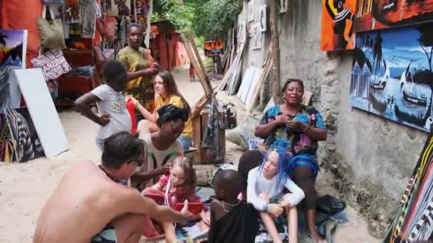 Afrikanska kvinnor väva afrikanska flätor till turister utomhus, Zanzibar Afrika — Stockvideo