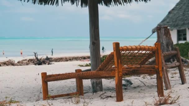 Židle na tropických palubách pod deštníky na písečné pláži u oceánu, Zanzibar — Stock video