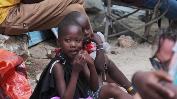 Lokalne głodne afrykańskie małe dzieci chodzić po ulicy wśród ludzi, Zanzibar — Wideo stockowe