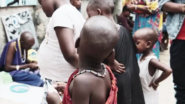 Lokalne głodne afrykańskie małe dzieci chodzić po ulicy wśród ludzi, Zanzibar — Wideo stockowe