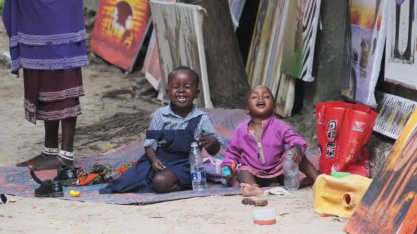 桑给巴尔，当地的非洲格里米快乐男孩和女孩坐在地上，玩耍，笑着 — 图库视频影像