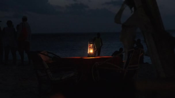 Romantic Candlelit Dinner by Ocean Beach at Night, Kerosene Lamp lit on Table — Stock Video