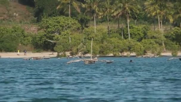 Pohled z oceánu na dřevěné rybářské lodě kotvící u pobřeží africké vesnice — Stock video