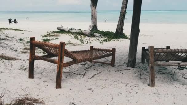 Scaune tropicale de punte sub umbrele Thatched la plaja de nisip de Ocean, Zanzibar — Videoclip de stoc