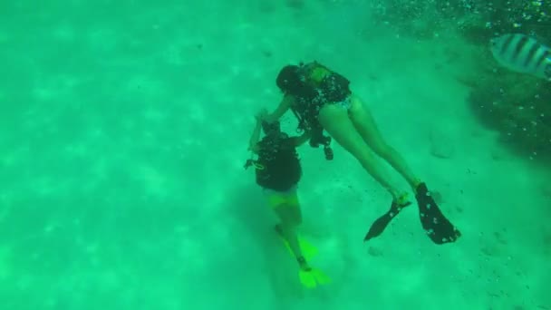 Scuba Diver Photographs a Woman Tourist with a Scuba Diving Underwater, Zanzibar — стокове відео