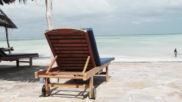 Lege ligbedden aan de overkant van de oceaan op Paradise Beach, Zanzibar, Achteraanzicht — Stockvideo