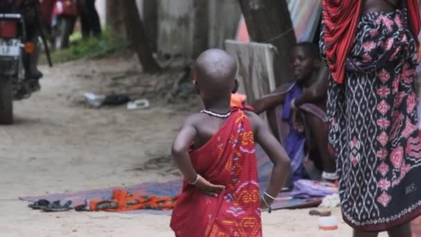 Miejscowe głodne afrykańskie dzieci spacerują wzdłuż ulicy turystycznej wśród ludzi, Zanzibar — Wideo stockowe