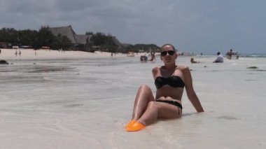 Siyah Bikinili Genç Kadın Cennetteki Beyaz Kumlu Kumsalda Ocean 'da yatıyor