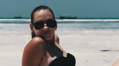 Siyah Bikinili Genç Kadın Cennetteki Beyaz Kumlu Kumsalda Ocean 'da yatıyor