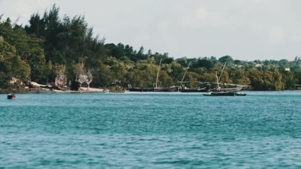 Blick vom Ozean auf hölzerne Fischerboote, die in der Nähe der Küste des afrikanischen Dorfes ankern — Stockvideo