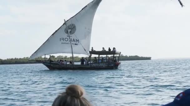 Tradiční africký člun Dhow s turisty plave pod otevřenou plachtou u oceánu — Stock video