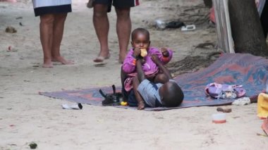Yerel Afrikalı Kirli Oğlan ve Kız Yerde Oturur, Oynar ve Gülümser, Zanzibar