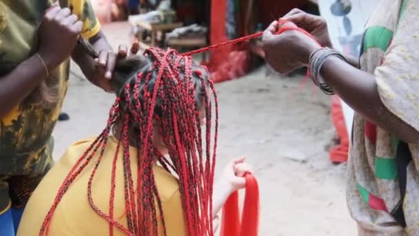 Donna africana tessitura trecce africane con Red Kanekalon Outdoor, Zanzibar Africa — Video Stock