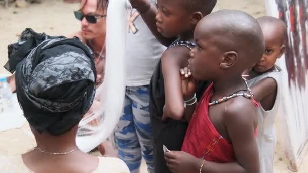 Niño hambriento africano local come papel en la calle entre la gente, Zanzíbar, África — Vídeos de Stock