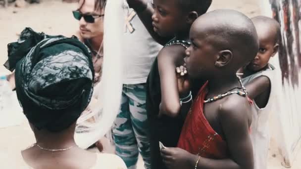 Local African Hungry Child Eats Paper på gatan bland människor, Zanzibar, Afrika — Stockvideo