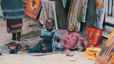 Yerel Afrikalı Kirli Oğlan ve Kız Yerde Oturur, Oynar ve Gülümser, Zanzibar