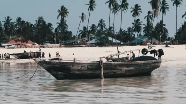 Tradiční africký dřevěný člun uvízlý v písku na pláži při odlivu, Zanzibar — Stock video