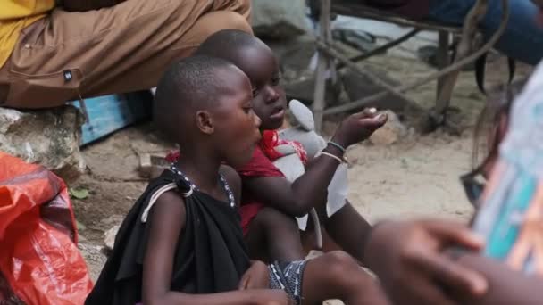 Miejscowy afrykański głodny dziecko zjada papier na ulicy wśród ludzi, Zanzibar, Afryka — Wideo stockowe