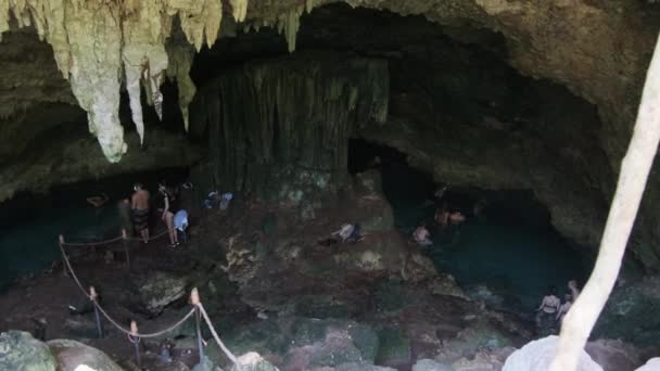 Люди в глубокой пещере плавают в подземных реках среди скал и скал, Занзибар — стоковое видео